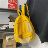 A yellow and beige canvas patchwork backpack hanging on a shelf.