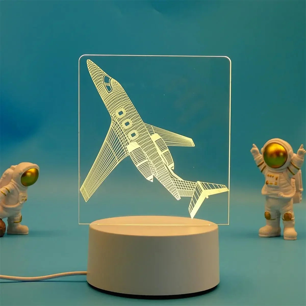 A white astronaut figure is displayed in front of a glowing 3D illusion LED night light lamp.