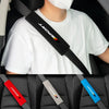 A person wearing a white t-shirt is holding a black and red car seat belt cushion set with various colored straps.