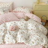 Pink floral bedding set featuring a duvet cover and pillows on a bed with a light wood dresser in the background.