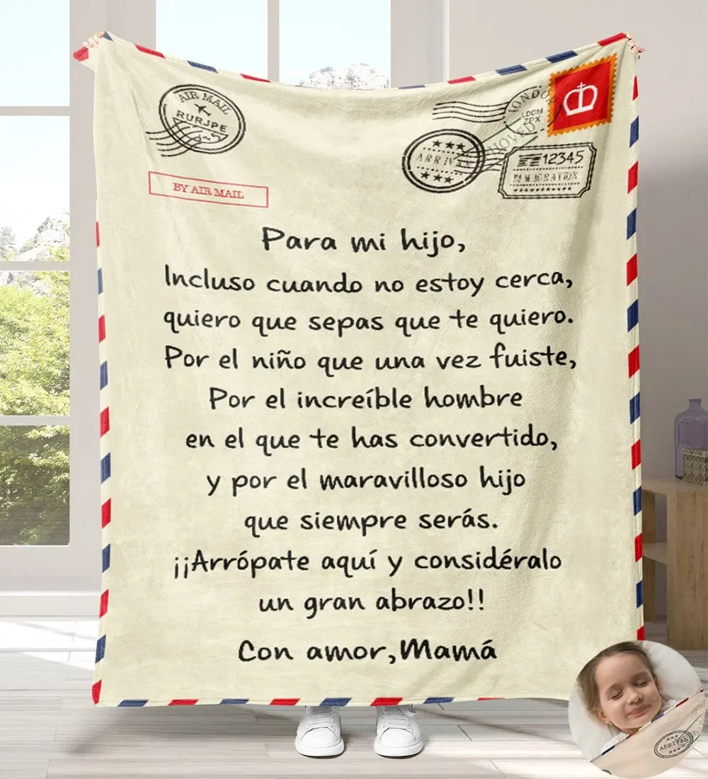 A cream-colored flannel throw blanket featuring a handwritten Spanish message for a child.