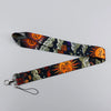 A black and gray patterned lanyard featuring orange sun and moon designs for an ID badge holder.