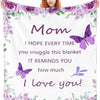 A woman holds a purple floral blanket featuring a butterfly design and the text I hope every time you snuggle this blanket it