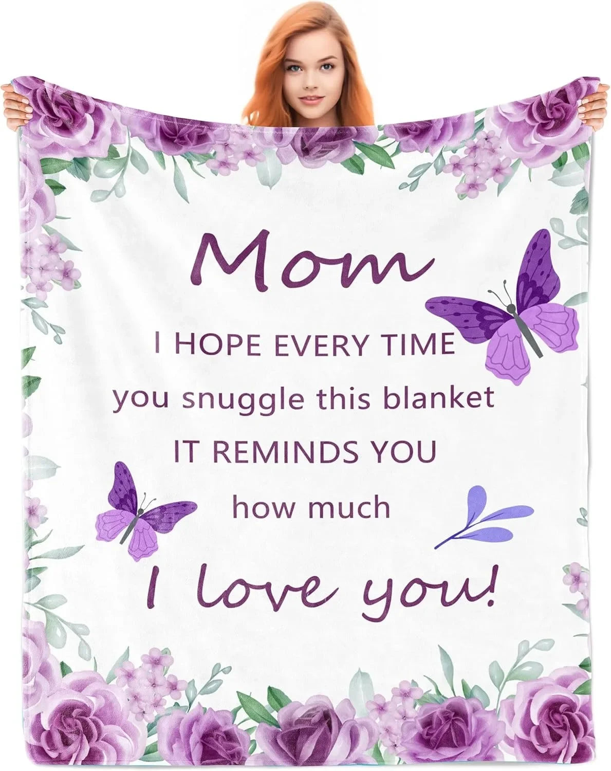 A woman holds a purple floral blanket featuring a butterfly design and the text I hope every time you snuggle this blanket it
