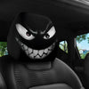 A close-up view of a black and white Evil Grin car headrest cover with an aggressive grin design on a car seat.