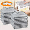 A stack of ten reusable steel wire scrubber dishcloths in gray and white patterns being used for cleaning.
