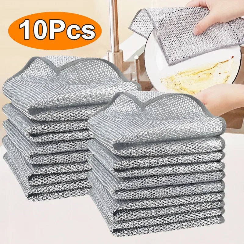 A stack of ten reusable steel wire scrubber dishcloths in gray and white patterns being used for cleaning.