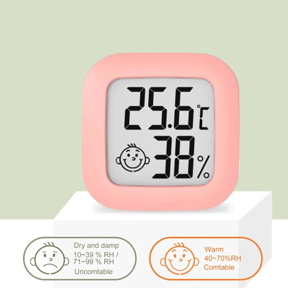 A pink compact digital indoor thermometer and hygrometer displaying 25.6°C and 38% humidity.