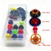 A clear storage box contains various colored spinning top customization accessories, including a black, blue, red, and yellow