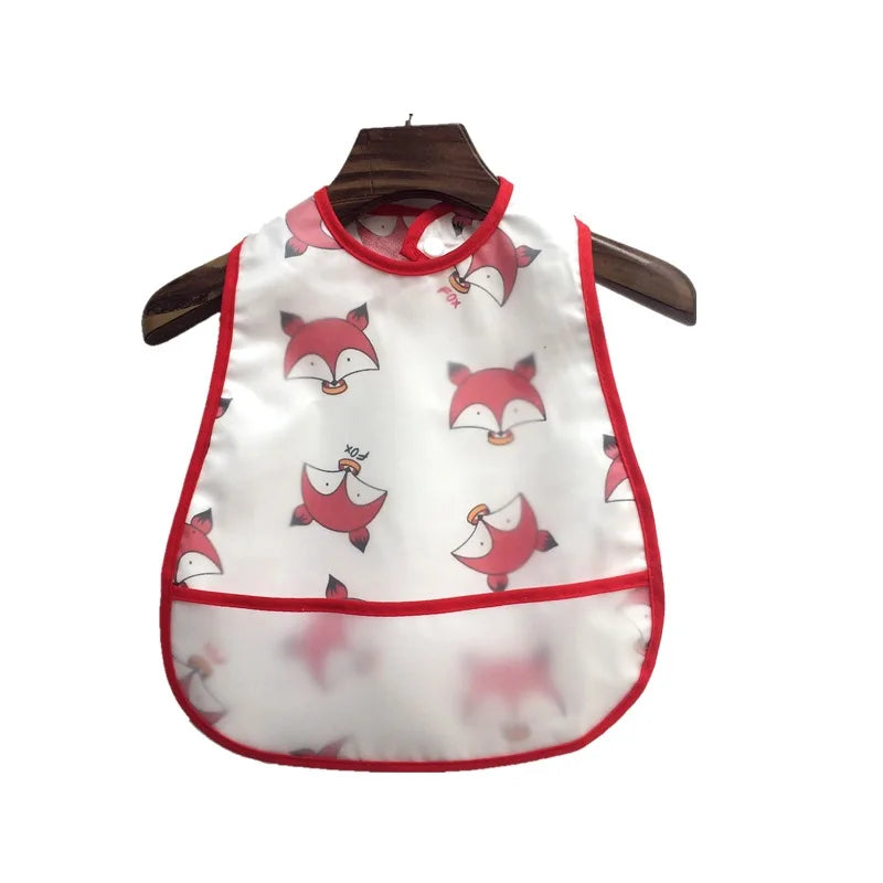 White baby feeding bib with pink fox designs and a catch pocket hanging on a wooden hanger