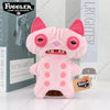 A pink Fuggler plush toy with large eyes and pink ears is displayed in front of its packaging.