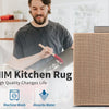 A woman and a man are shown in a kitchen setting, with a rug being worked on. The product is a non-slip kitchen rug.