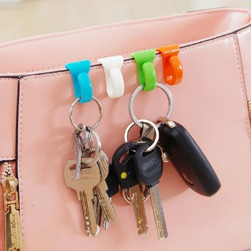 A set of colorful key holder clips attached to a pink leather bag.