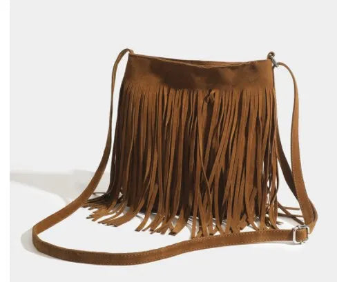 A brown bohemian fringe shoulder bag with long tassels is displayed against a light background.