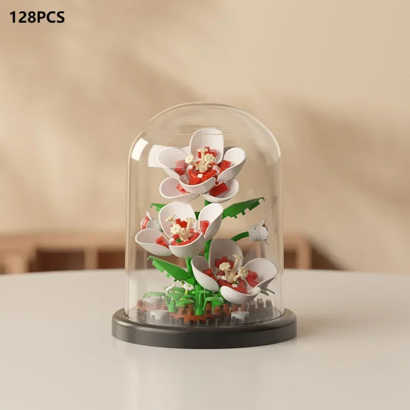 A clear glass dome display of a miniature eternal rose bouquet made from building blocks.