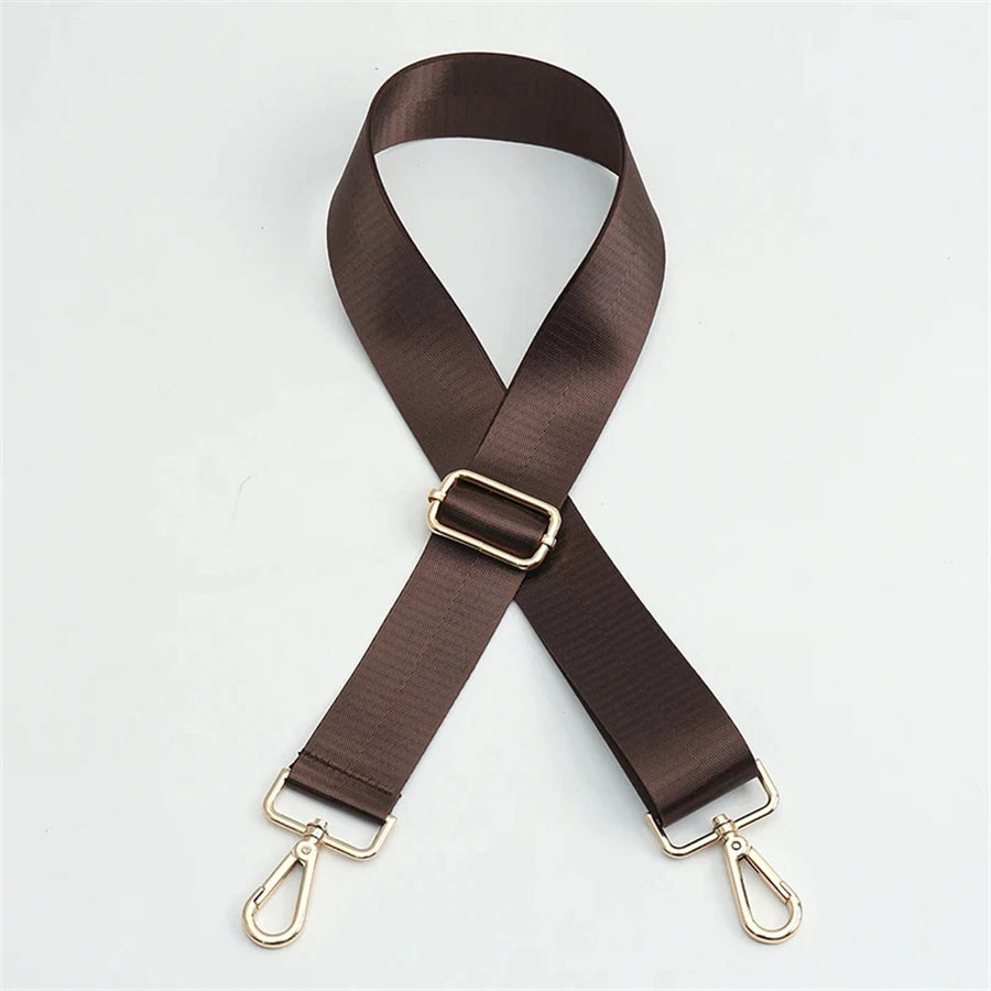 A dark brown nylon bag strap with a gold buckle shown in an 'X' shape.