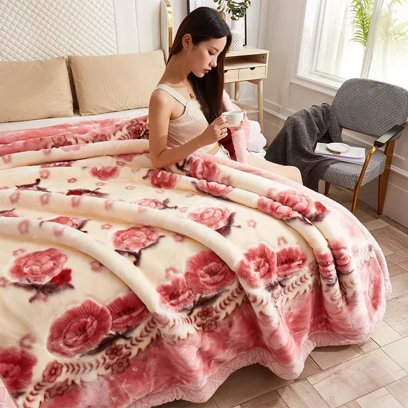 A pink and cream weighted plush raschel blanket draped over a bed in a bright room.