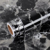 A roll of waterproof self-adhesive marble wallpaper, silver and white marbled pattern, lying on a dark marble surface.