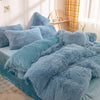 A fluffy blue mink velvet duvet cover set with sheets displayed on a bed.