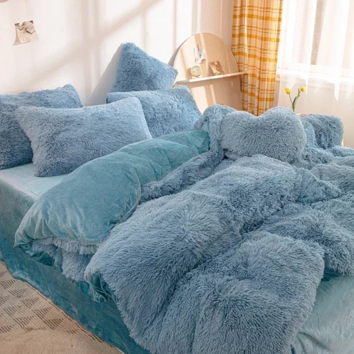 A fluffy blue mink velvet duvet cover set with sheets displayed on a bed.