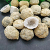 A cluster of natural agate geode crystals in various light brown and translucent forms.