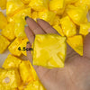 A hand holds several bright yellow, squishy fidget cubes for stress relief.