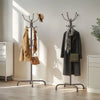 A freestanding metal coat rack with 14 hooks displaying coats and accessories in a bright room.