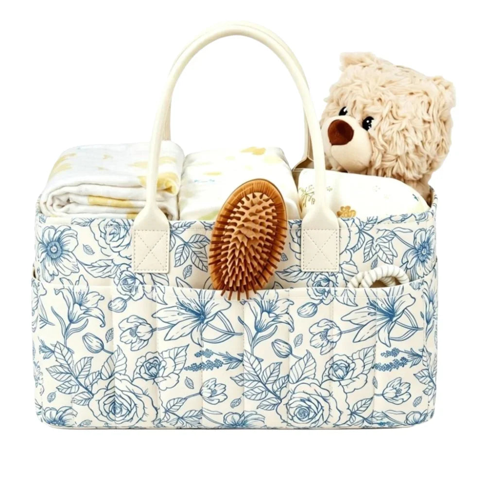 A floral patterned diaper organizer bag featuring multiple compartments and a teddy bear toy.