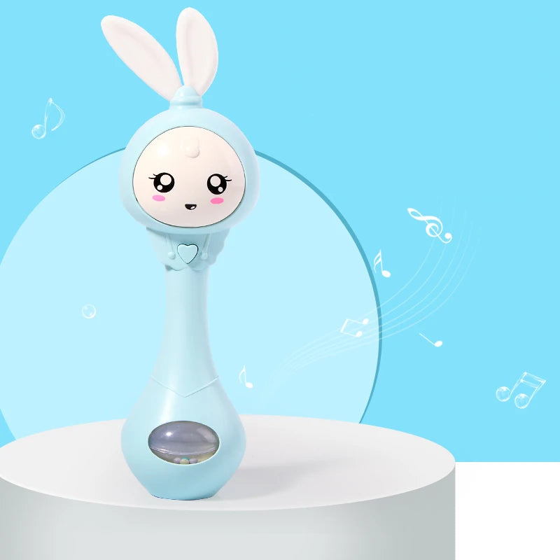A light blue musical rabbit rattle and teether toy standing on a white surface against a light blue background.