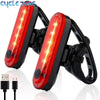A pair of red bicycle tail lights with integrated USB charging ports and four operating modes.
