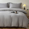 A gray washed cotton brushed duvet cover with matching pillows and bedding on a bed.