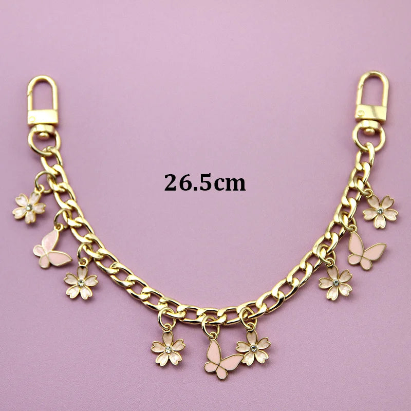 A gold-colored chain necklace featuring small flower charms and butterfly pendants.