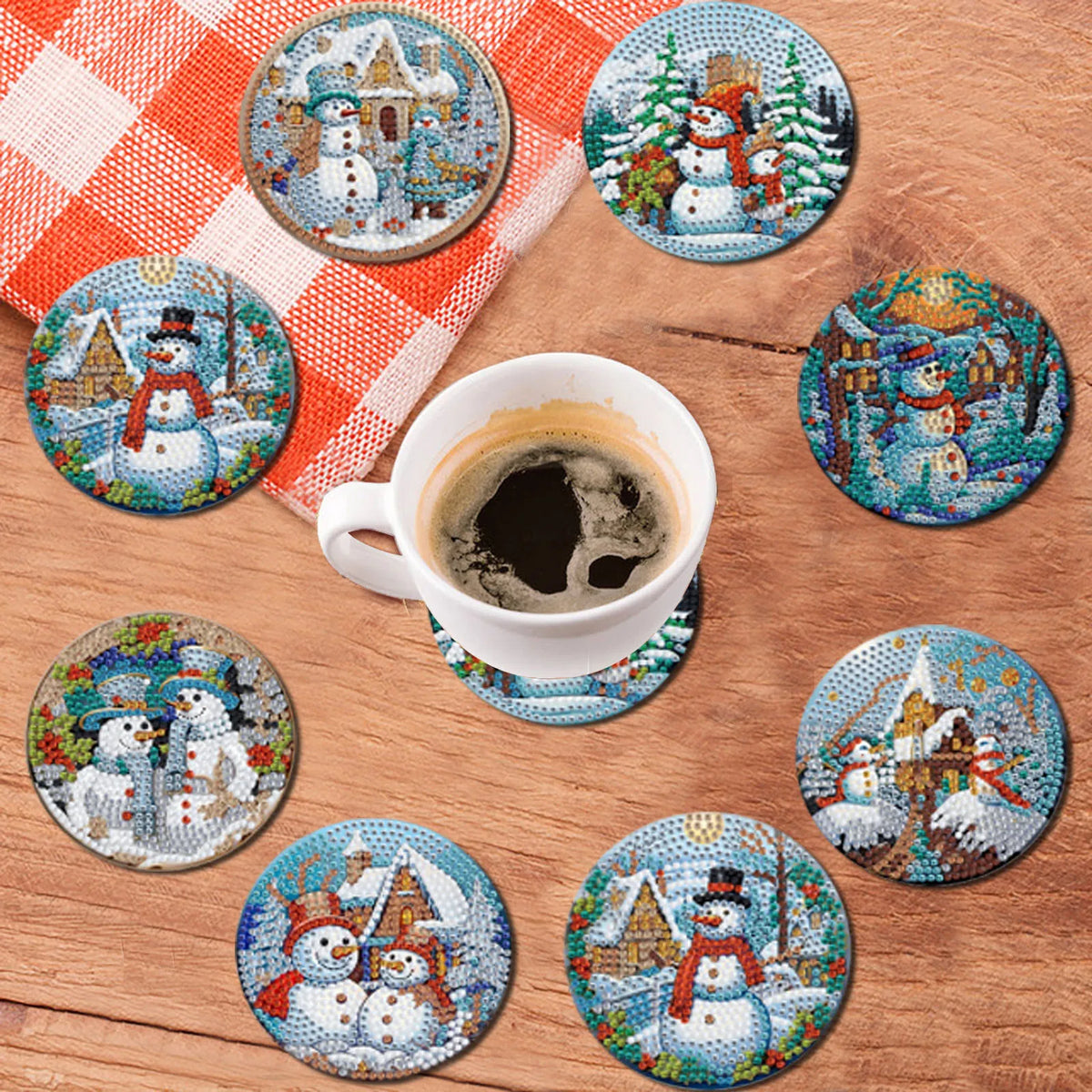 A collection of eight diamond art coasters featuring winter and holiday scenes on wooden bases.