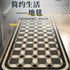 A rectangular kitchen rug featuring a classic geometric pattern in shades of beige, brown, and black on a light wood floor.