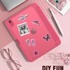 A pink slim tri-fold stand case for an iPad is shown with various decorative stickers and a white pen nearby.