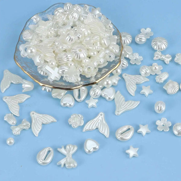 Une pile de perles acryliques claires et irisées, rondes, plates et en forme de feuille, sur un plat en verre.