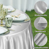 Elegant silver satin tablecloth draped on a round table with glassware and silverware.