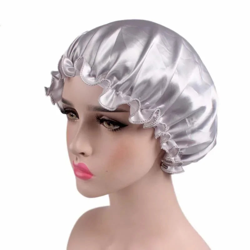 A silver satin hair bonnet is displayed on a mannequin head.
