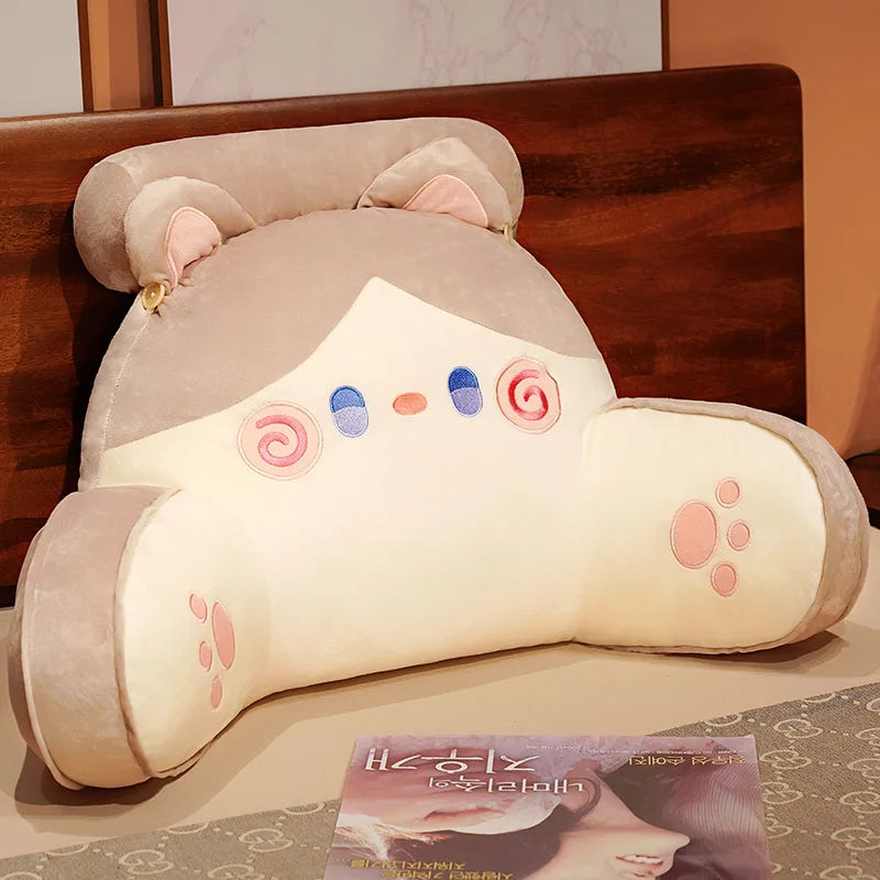 A light beige plush cushion shaped like a cat's head with pink accents, used as a backrest for furniture.