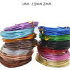 A collection of anodized aluminum jewelry wire in various colors including purple, blue, green, black, and copper.