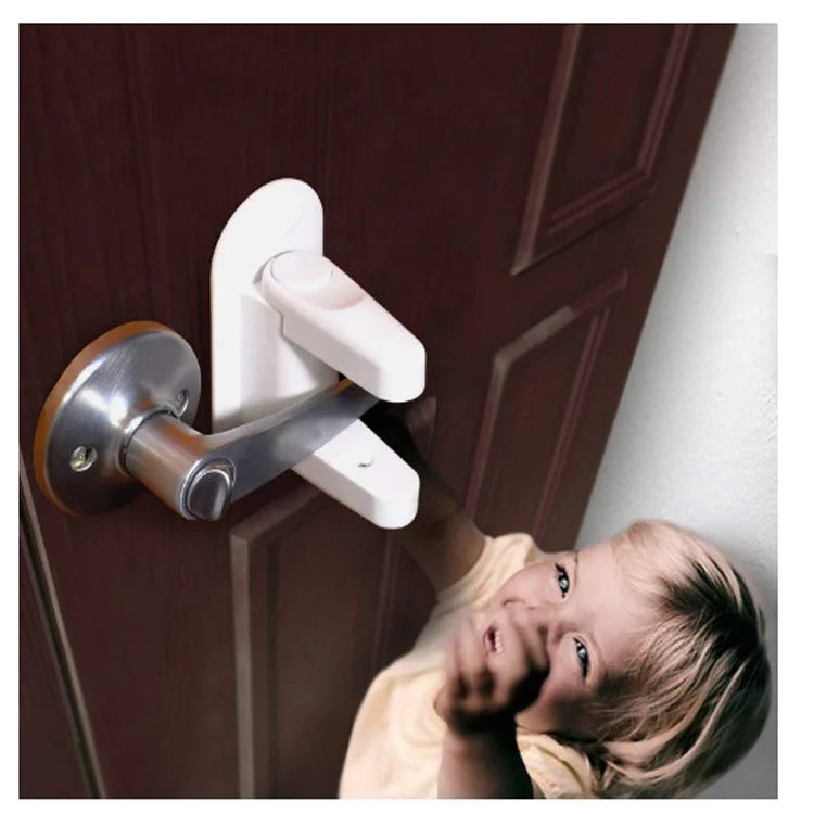 A young child is attempting to open a door with a white safety latch installed on the handle.