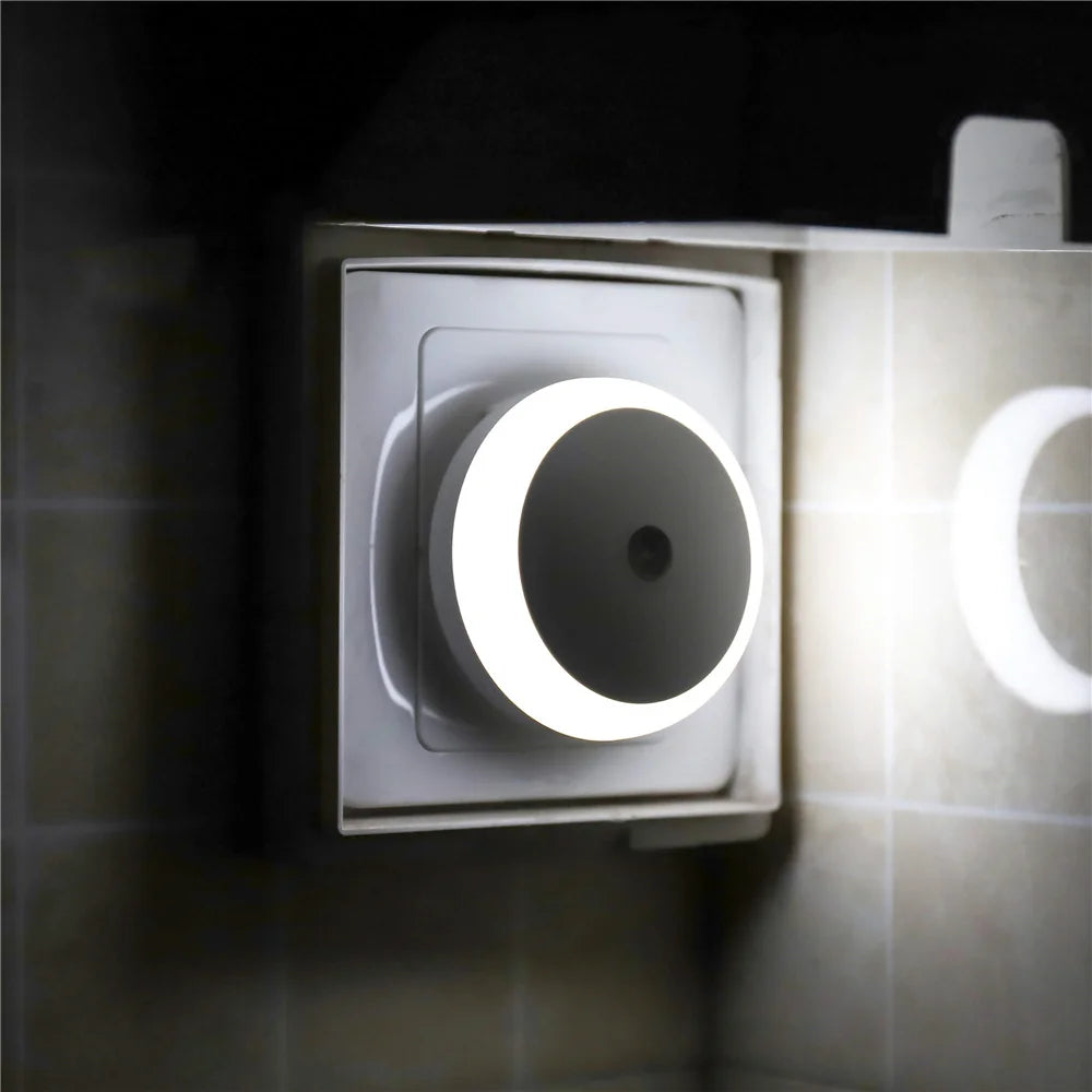 A white smart sensor night light fixture mounted on a wall, emitting a soft glow.