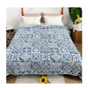 A blue and white patchwork cotton bedspread displayed on a bed with white pillows.