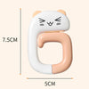 A white silicone portable bag hook shaped like a cat, used for hanging items on tables or desks.