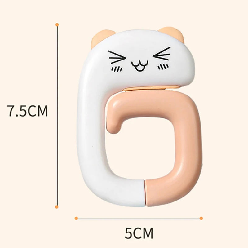 A white silicone portable bag hook shaped like a cat, used for hanging items on tables or desks.
