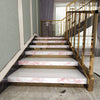 A staircase with pink marble steps and gold railings in a modern interior setting.