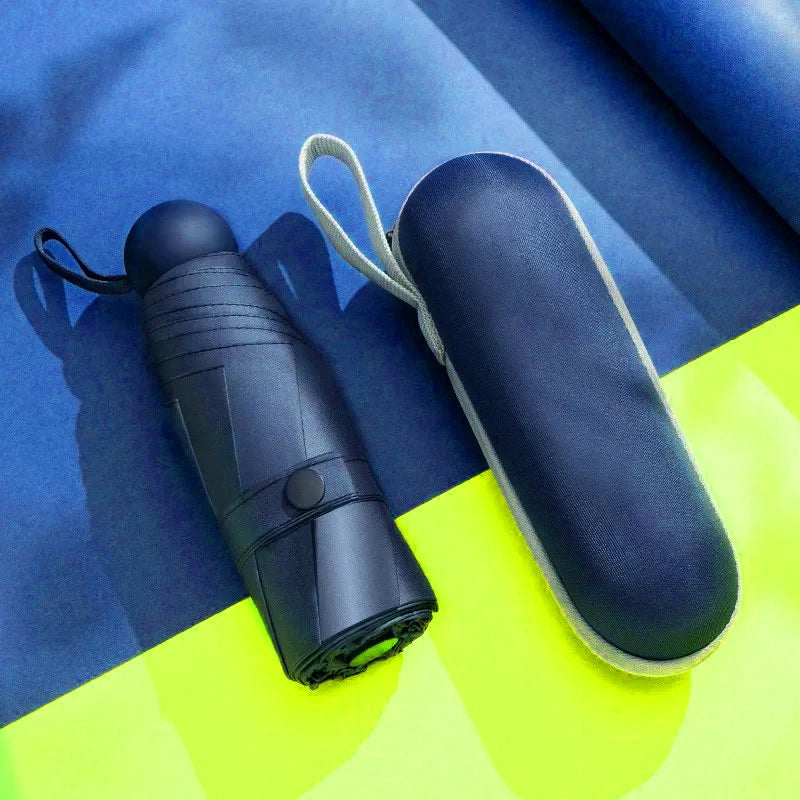 A dark blue compact 5-fold travel umbrella with a light gray strap is shown against a blue and yellow background.