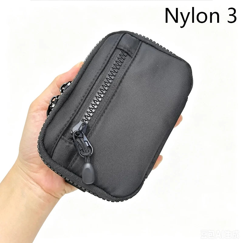 A hand holds a black Nylon 3 utility pouch with a zipper and a small attached loop.