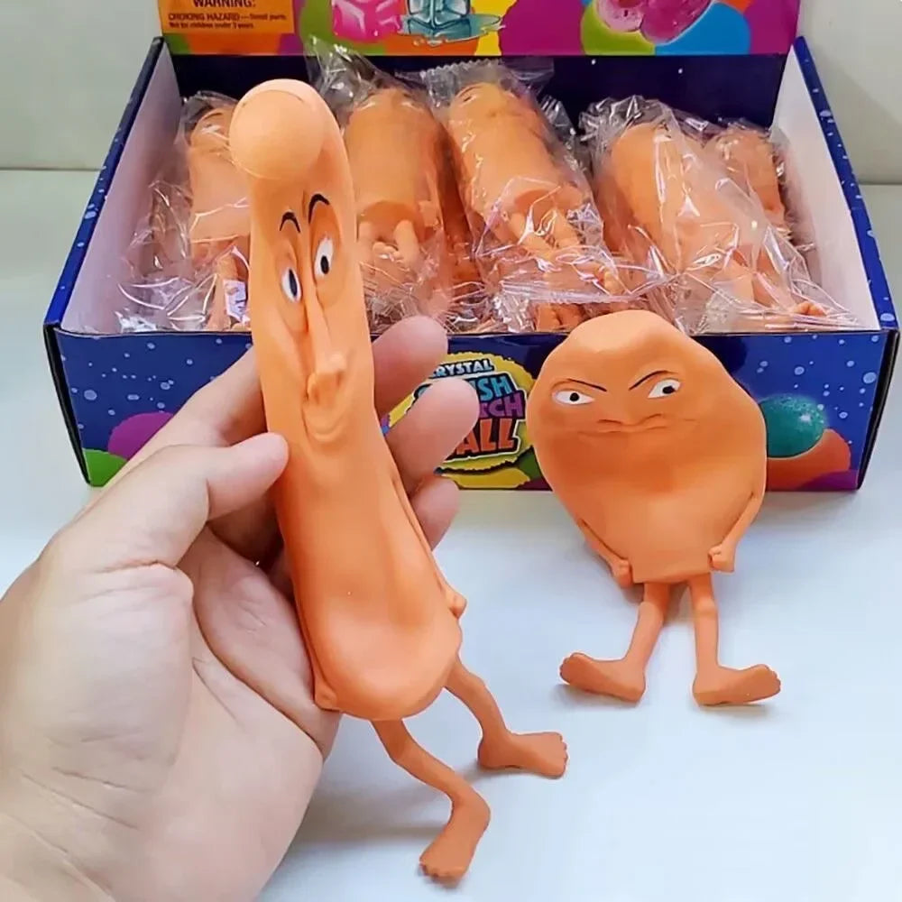 An orange squishy stress relief toy shaped like a character is held in a hand next to its packaging.