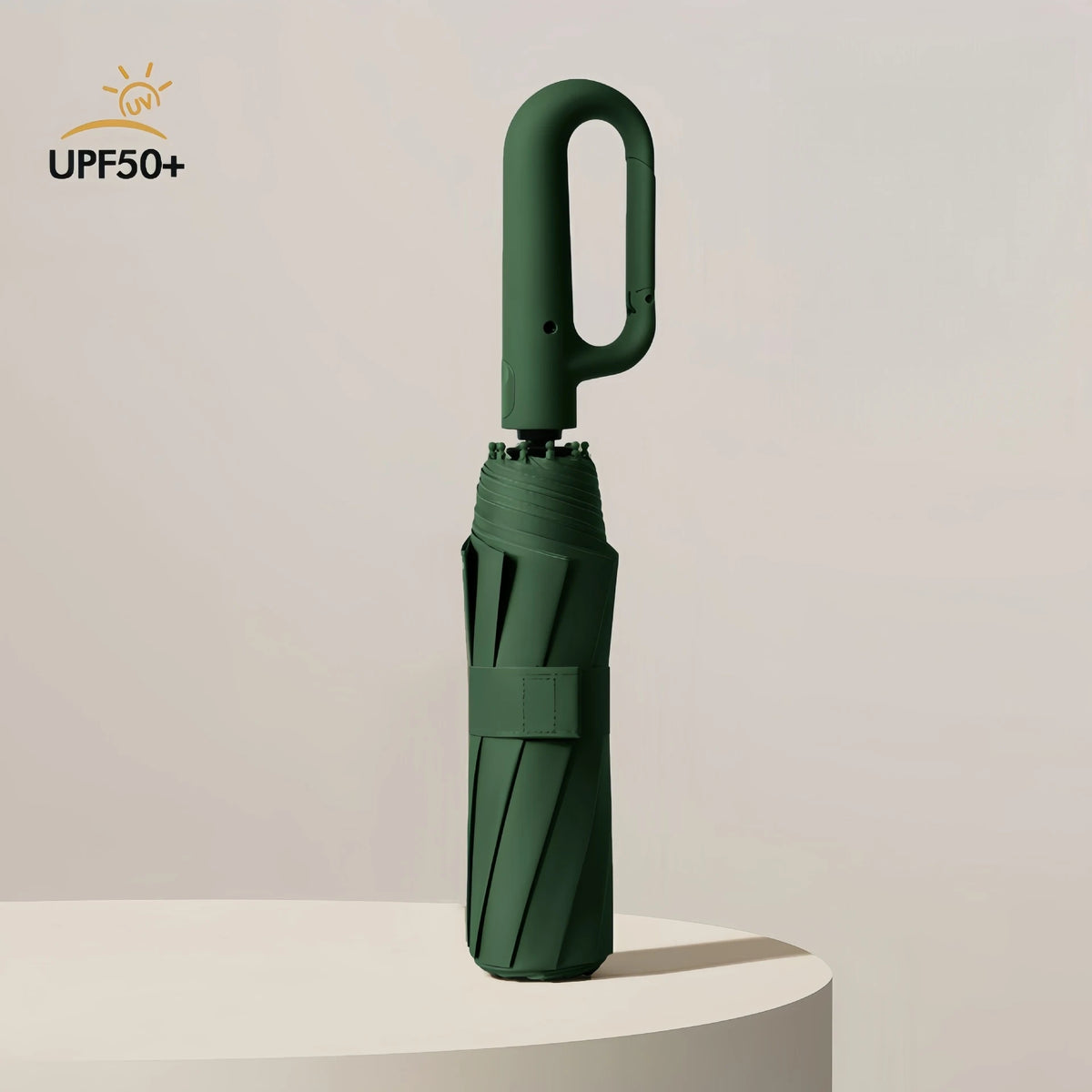 A dark green fully automatic windproof folding umbrella standing upright on a white surface.